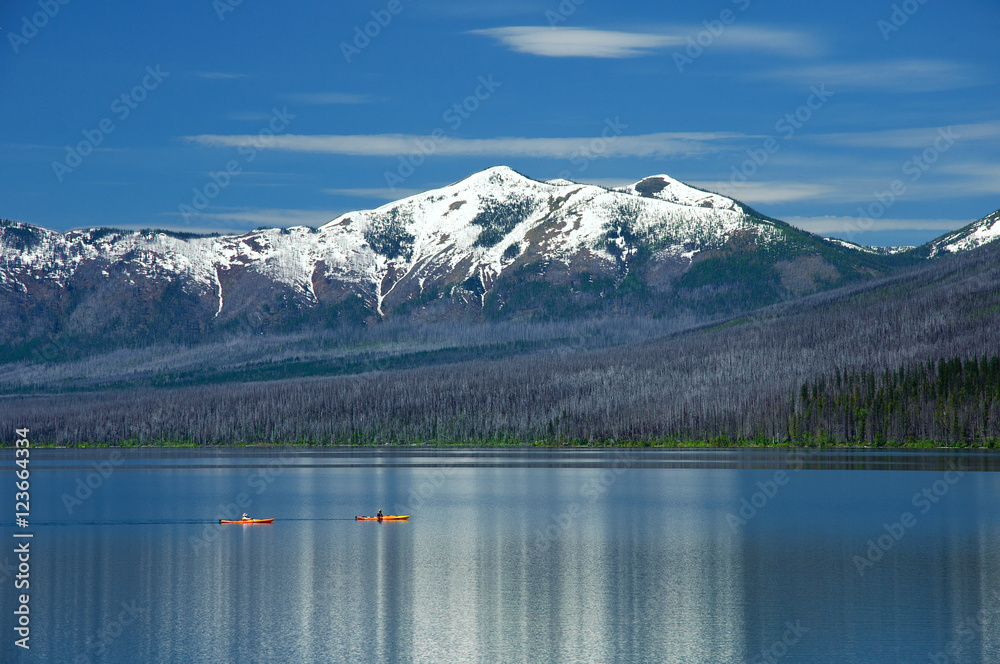 Kayaking by snow covered mountains in Glacier National Park Montana