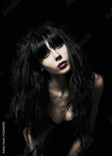 Portrait of beautiful goth girl among the darkness
