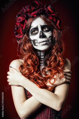 Sad young woman with muertos makeup (sugar skull)