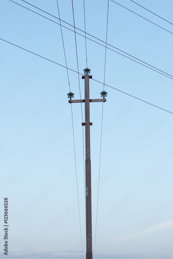 Electricity post in the middle of the frame with a blue sky