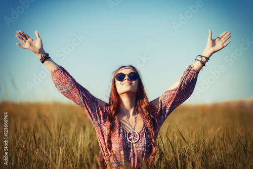 Εκτύπωση καμβά Beautiful young hippie woman sitting in a field and praying to God