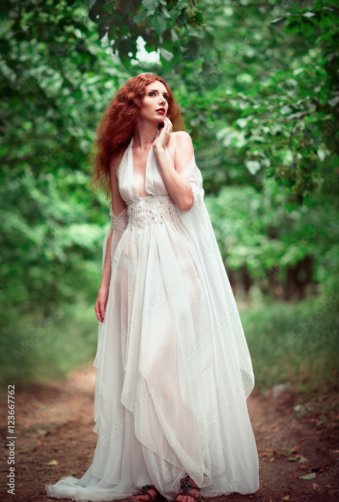 Beautiful ginger woman wearing white dress in a grove Beautiful ginger woman wearing white dress in a grove