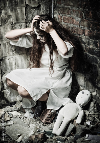 Horror style shot: strange crazy girl and her moppet doll