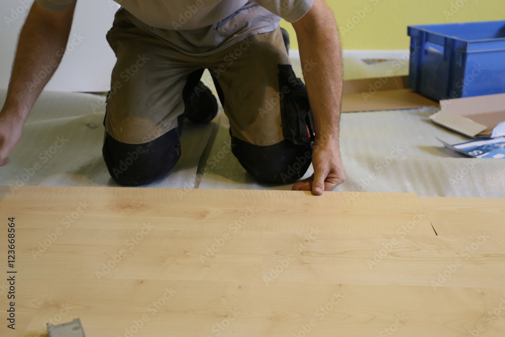Handwerker verlegt Laminatfußboden Handwerker verlegt Laminatfußboden
