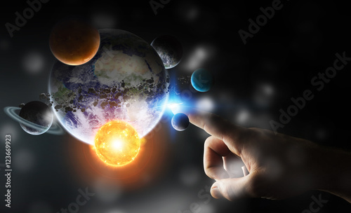 Businessman touching solar system with his fingers