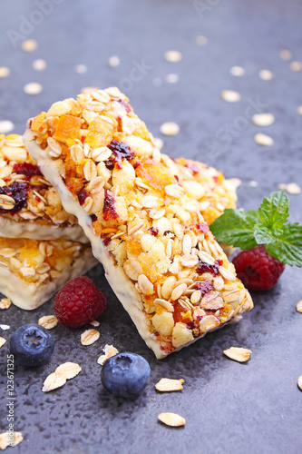 healthy snack, muesli bars with raisins and dried berries on a black background