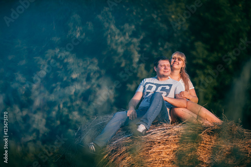 love story man and woman on the background of haystacks sun