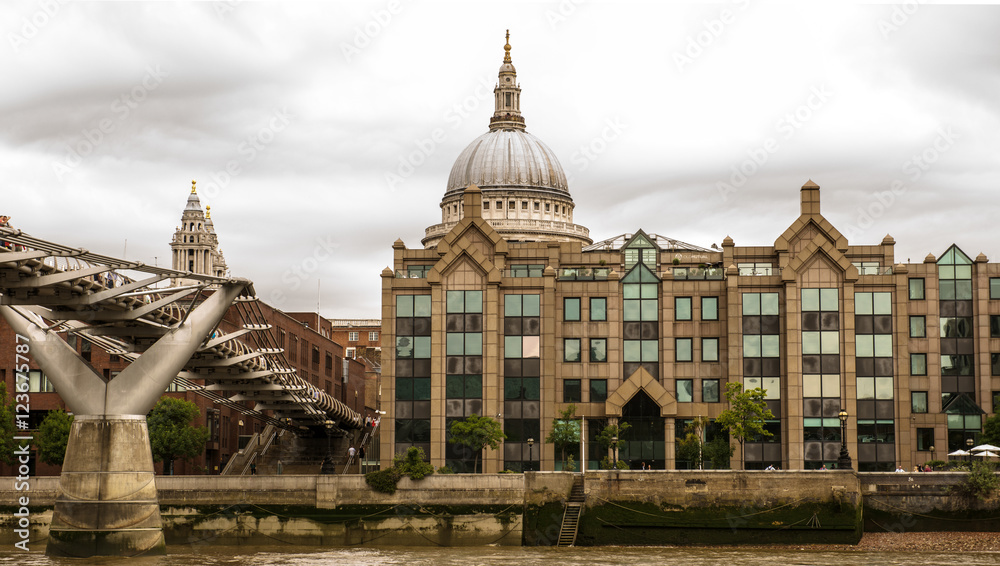 View of the Millennium pedestrian footbridge across the River Thames in London, England with the dome of St. Paul's Cathedral in the background