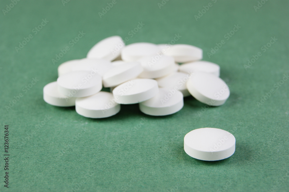 white tablets on a green background white tablets on a green background