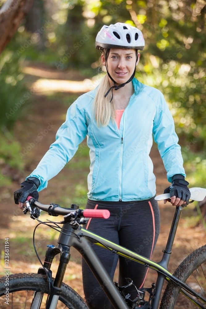 Obraz premium Portrait of female mountain biker with bicycle