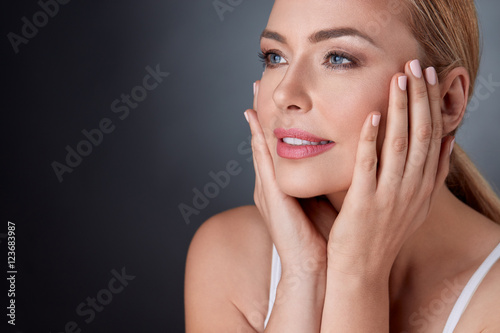 Quadro su tela Pleased  woman touching face
