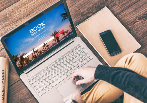 Man using a modern laptop for booking hotel online. Tour reservation photo