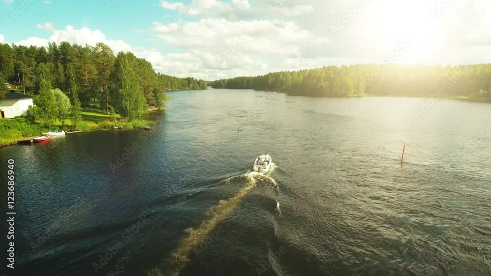 Aerial Shot of Motor Boat sailing on River Surrounded by Pine Forest. 