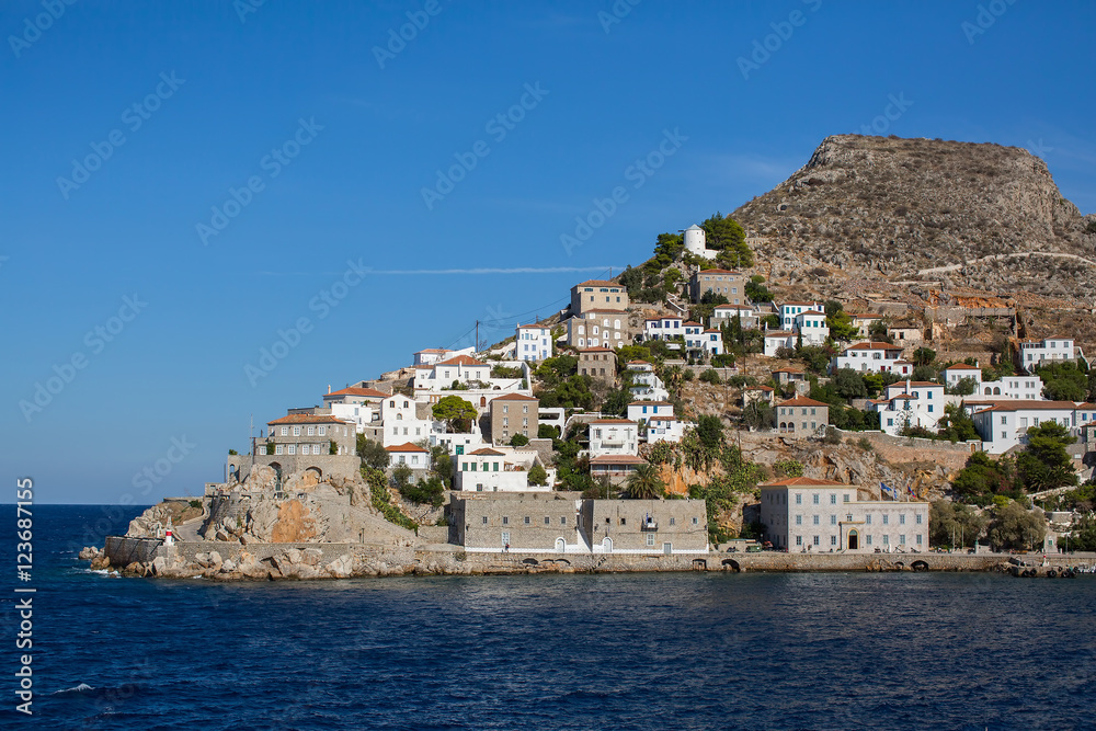 Coast with buildings and the entrance to the Marina on the Hydra island, Greece.