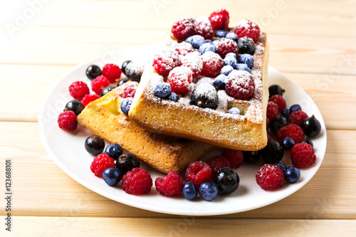 Belgian waffles with blueberry and raspberry powdered by caster