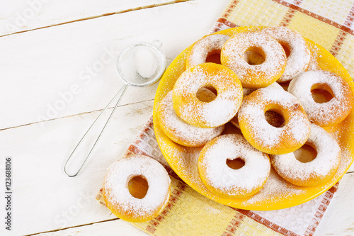 Schilderij op canvas Donuts with caster sugar served on yellow plate top view copy sp
