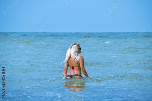 Beautiful blonde walks into the sea water