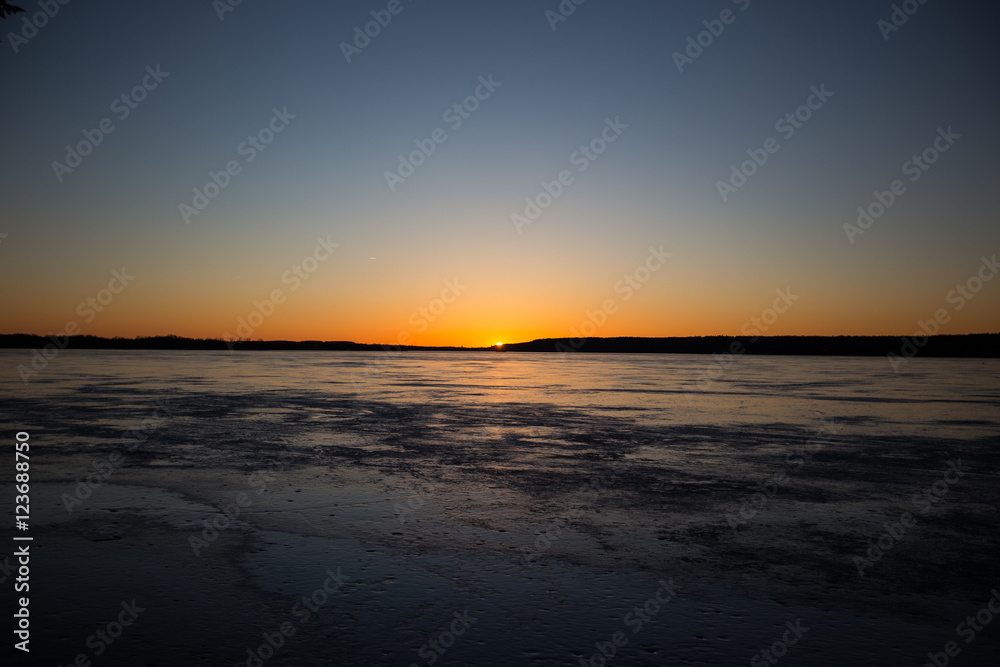 Sunset over a frozen lake in winter