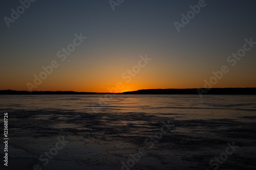 Sunset over a frozen lake in winter