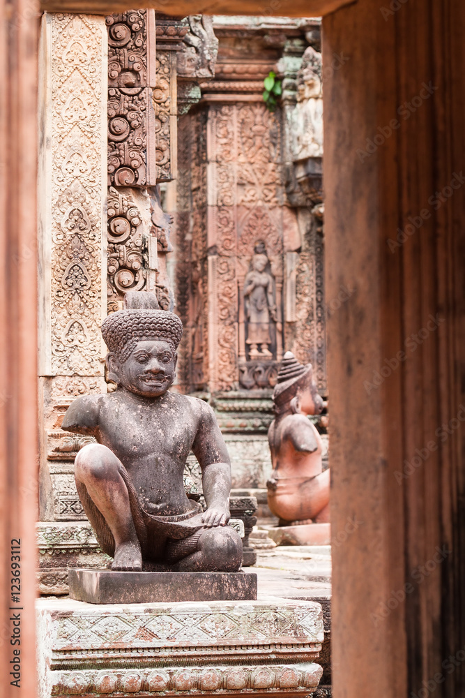 Ancient pink stone guardian statue carvings in Banteay Srei, Siem reap, Cambodia.