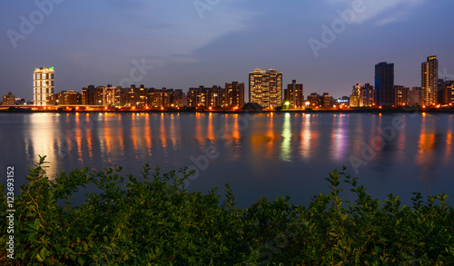 Colorful Taipei city lights reflecting in the Tamsui River at night in Taiwan photo