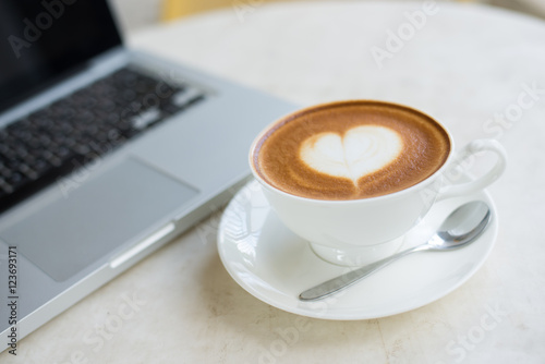 Laptop and coffee cup on wooden table