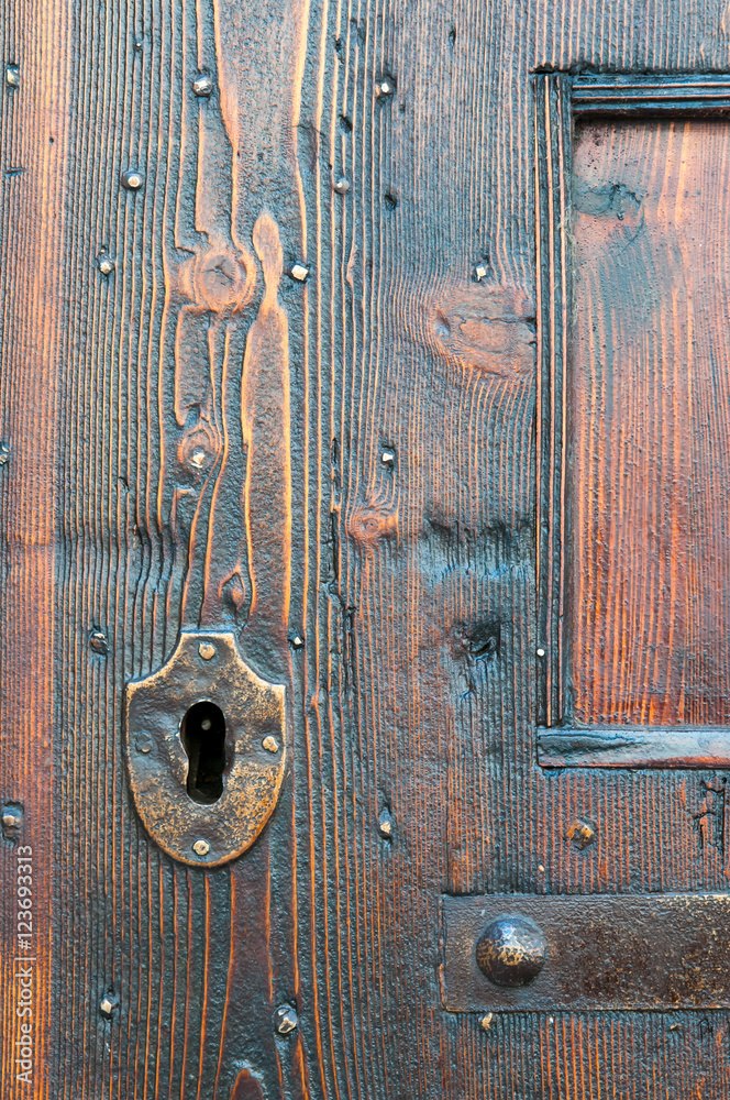 Closeup view of a metal keyhole of an old wooden door Closeup view of a metal keyhole of an old wooden door