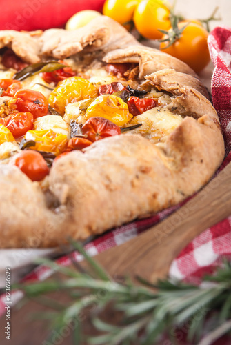 delicuious pie with cherry tomatoes, feta cheese herbs photo