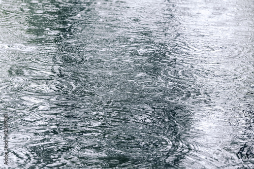raindrops and water circles on flooded pavementraindrops and water circles on flooded pavement during downpour