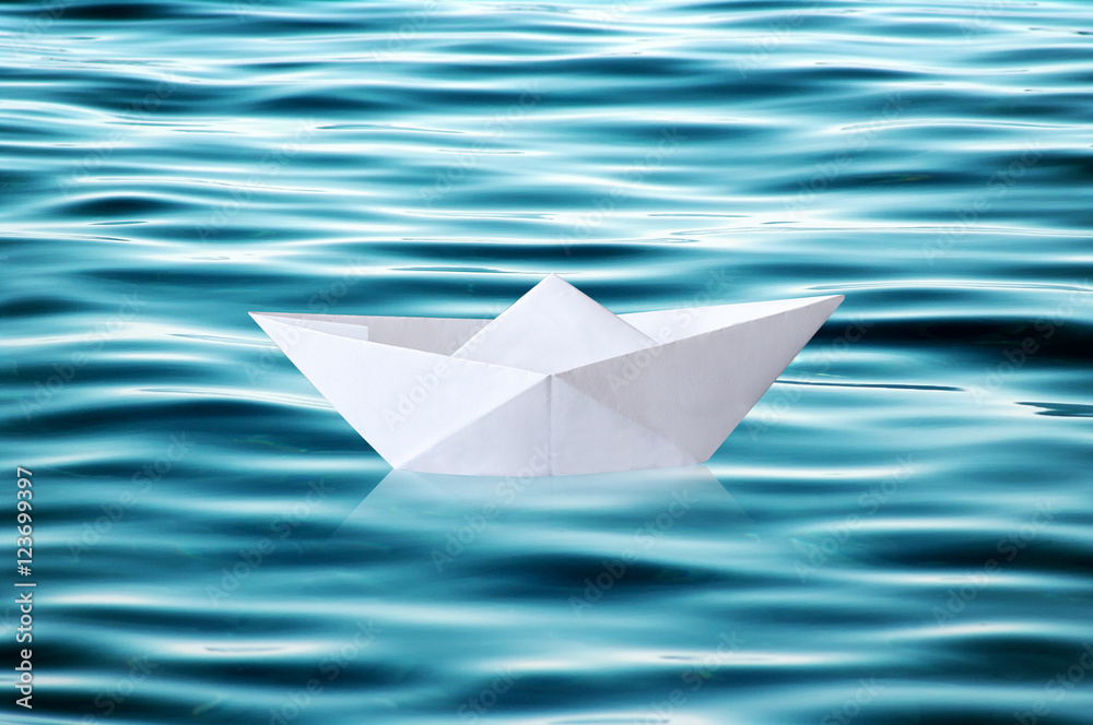 Paper boat floating on rippled water