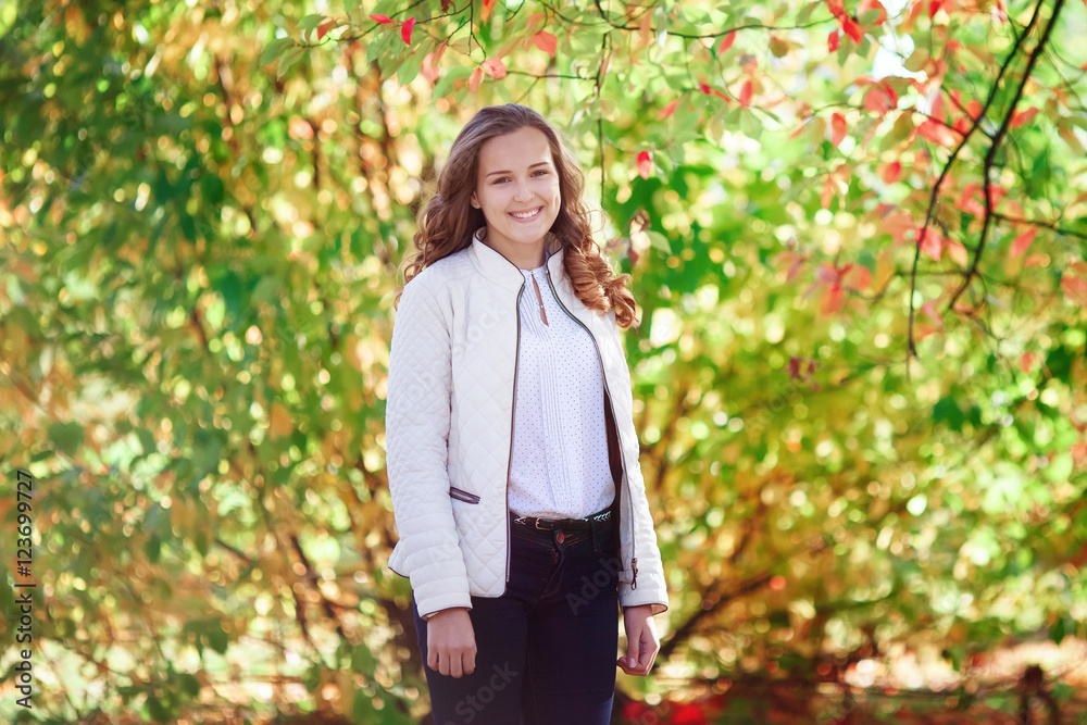 Young beautiful woman. Beauty smiling teenager girl in autumn park Young beautiful woman. Beauty smiling teenager girl in autumn park