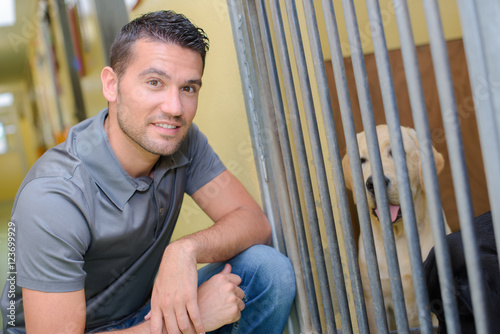 Man next to dog kennel