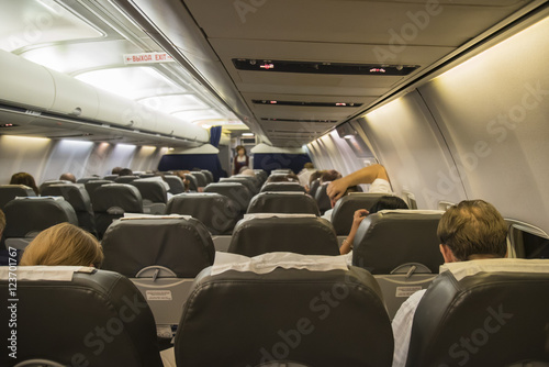 Interior of airplane with passengers on seats waiting to taik off.