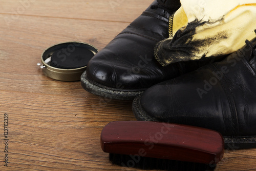 Shoes and cleaning equipment on a wooden floor