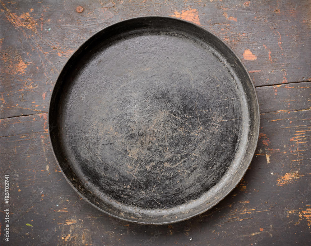 Old Cast Iron Frying Pan On The Black Wooden Table Close-Up Top View