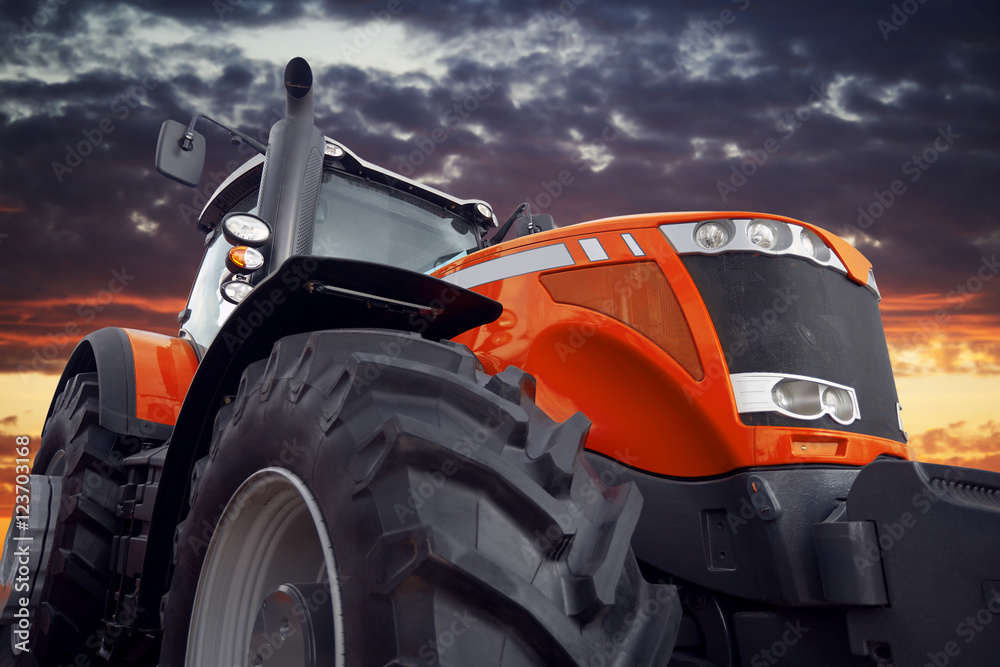 Obraz premium Farm tractor working at sunset