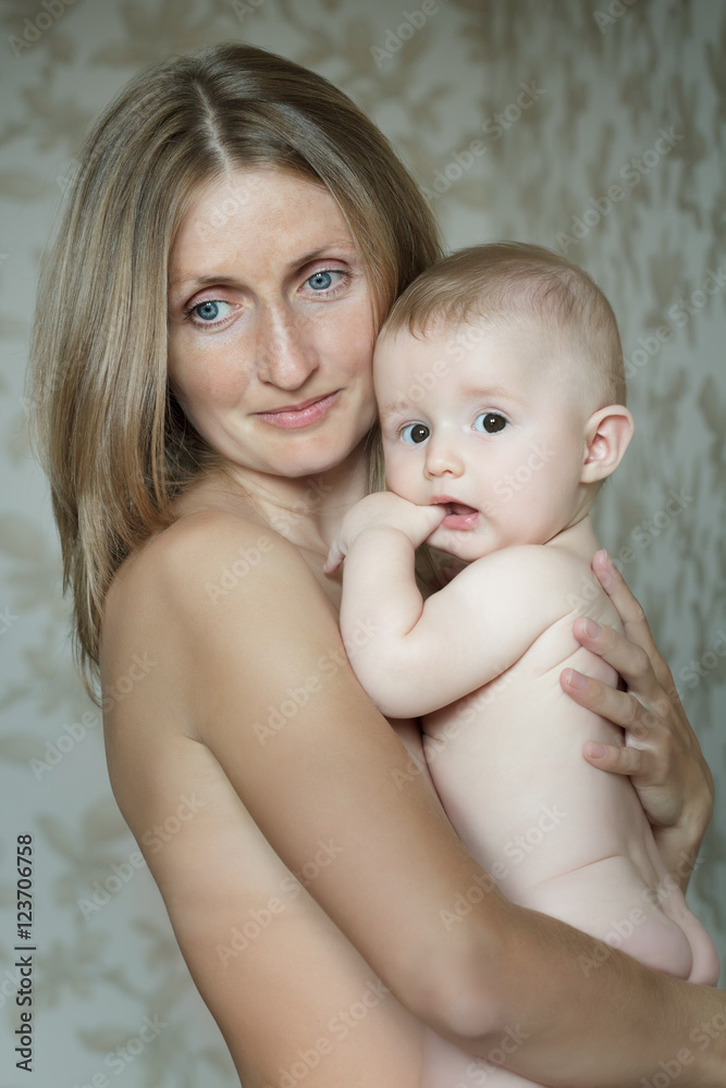 Family portrait of blue-eyed mother holding her baby child Family portrait of blue-eyed mother holding her baby child