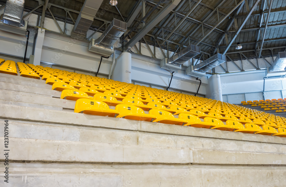 Fototapeta premium empty yellow seats at indoor stadium