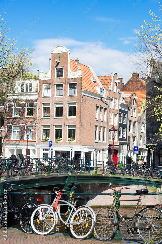 Houses and bicycles standing next to canal in Amsterdam, Netherlands