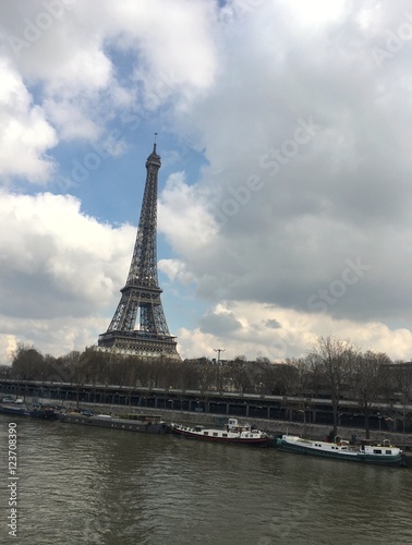 PARIS, FRANCE - FEBRUARY 25, 2016 : view of the Eiffel Tower along the Seine river and bridge crossing the river during winter 