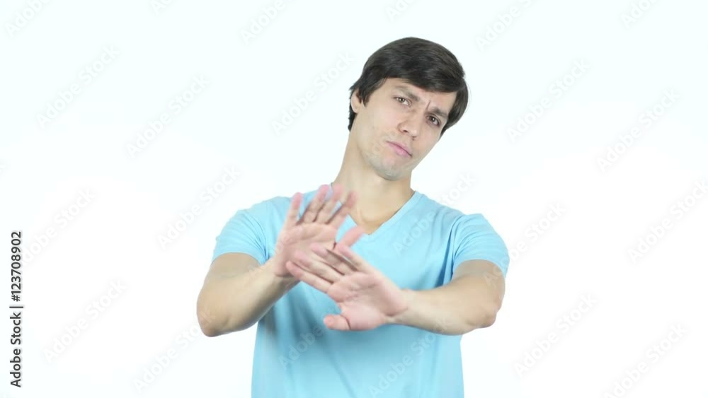 Denying, Refusing, Disliking Gesture by Young Casual Man, White Background Denying, Refusing, Disliking Gesture by Young Casual Man, White Background