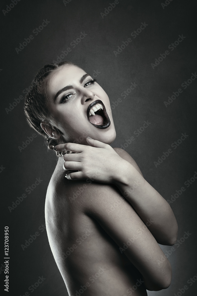 Fototapeta premium Female vampire showing fangs