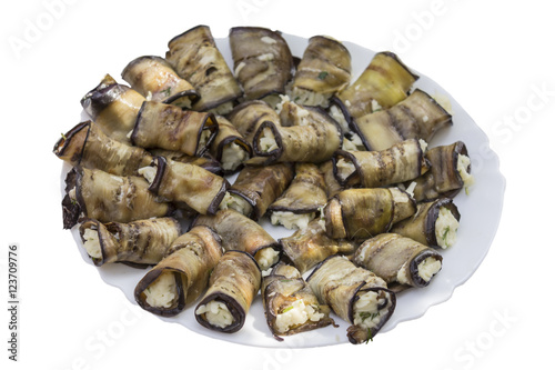 Eggplant rolls with cheese and nuts in a plate on a white background.Site about food, snack, cheese , vegetables, traditional cuisine .