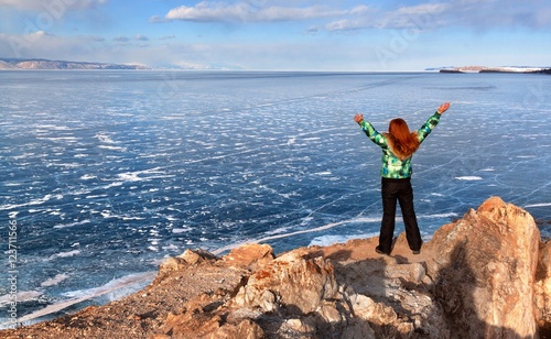 Freedom happy redhead woman with arms rised enjoying view of a frozen lake Baikal surface