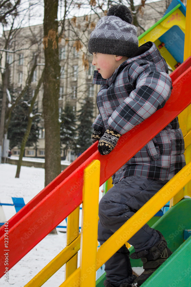 Boy climbing down the ladder on the playground