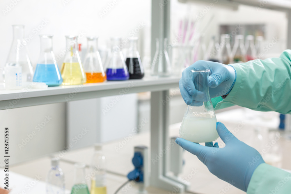 Hands in latex gloves holding flasks in the laboratory Hands in latex gloves holding flasks in the laboratory