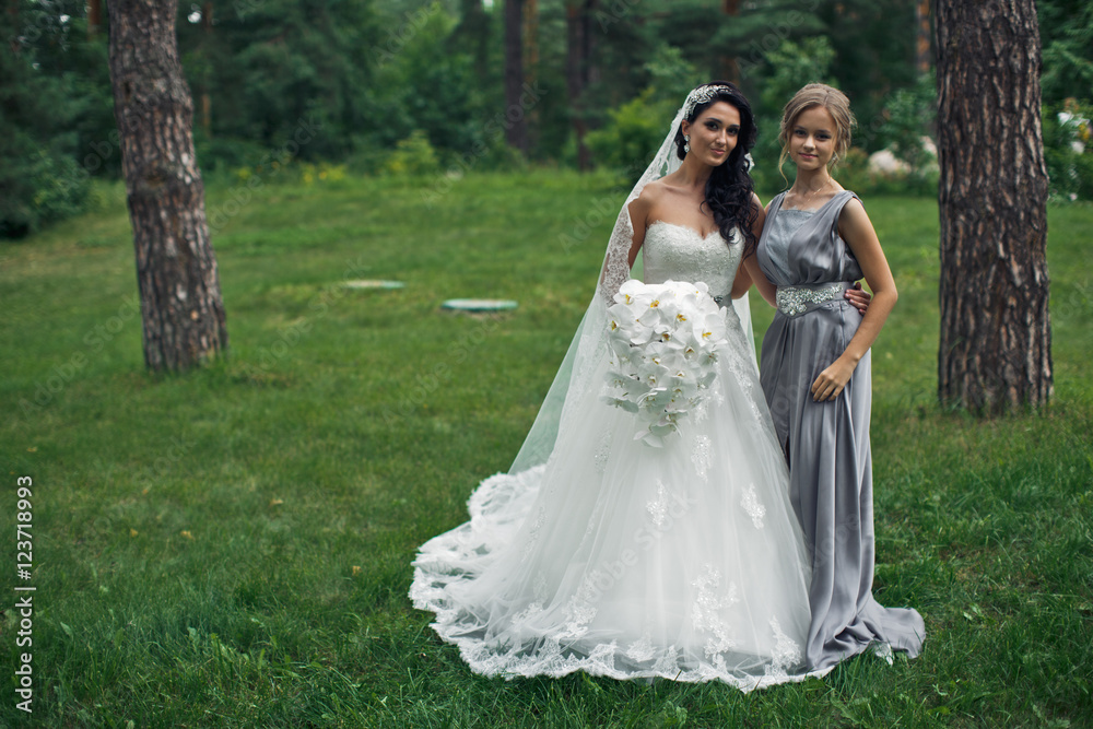 The tenderness bride with bridesmaid in the park