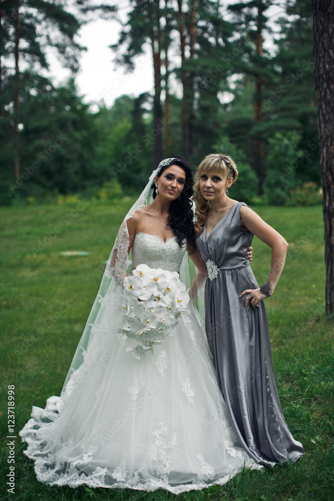 The tenderness bride with bridesmaid in the park