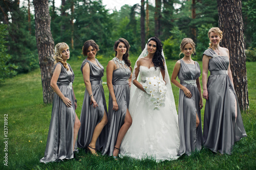 The tenderness bride with bridesmaids in the park
