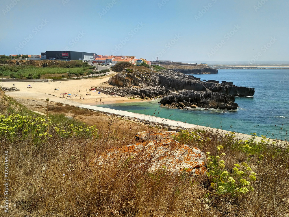 Coastline with beach and buildings near Cabo Carvoeiro in daylight, Peniche